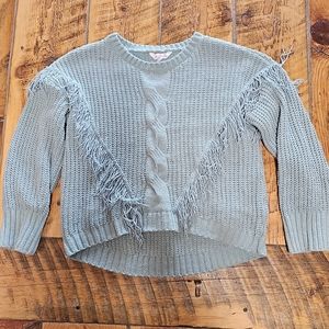 Mint green knit sweater with fringe.